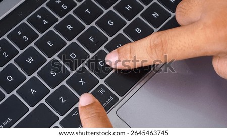 Full frame of finger pressing command and V letter button or cmd + V on a laptop keyboard, shortcut keys for paste isolated on black background