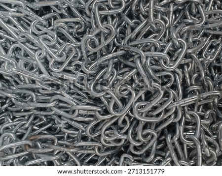 A full frame, high-angle close up of a tangled pile of medium gauge, galvanized or chrome-plated metal chains