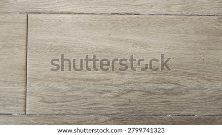 Full frame high-angle shot of durable ceramic tile flooring featuring a realistic light brown wood grain texture and grout lines, ideal for modern interior design backdrops.