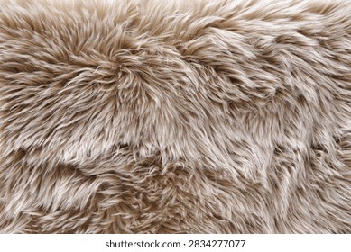 Full frame macro background of soft beige fluffy faux fur rug pile. Ideal texture for cozy winter decor, warm fashion textiles, and luxury lifestyle backgrounds.