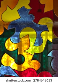 Full frame macro texture of multicolored stained glass door with backlighting and mosaic pattern