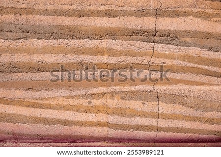 Full frame shot of an earthen wall texture of clay house structure. These walls are constructed by ramming a mixture of aggregates, including gravel, sand, silt and a small amount of clay.
