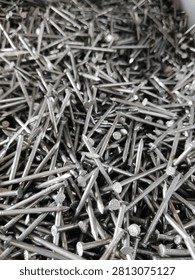 Full frame texture background of stacked metallic iron nails, close up view.