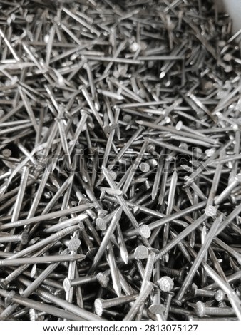 Full frame texture background of stacked metallic iron nails, close up view.