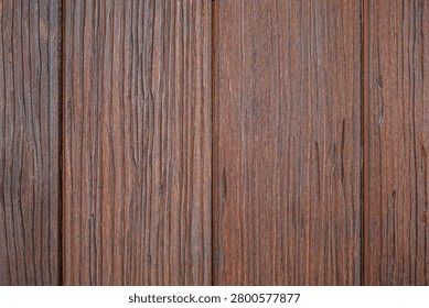 Full frame texture of dark brown vertical wood panels.