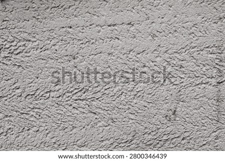 Full frame texture of a light grey stucco cement wall with horizontal roughcast trowel patterns, ideal for architectural or abstract industrial backgrounds.