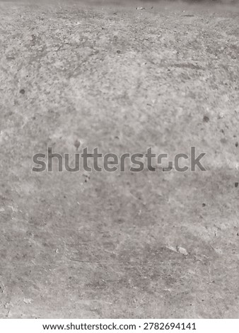 Full frame texture of a raw grey concrete surface with aggregate details. 