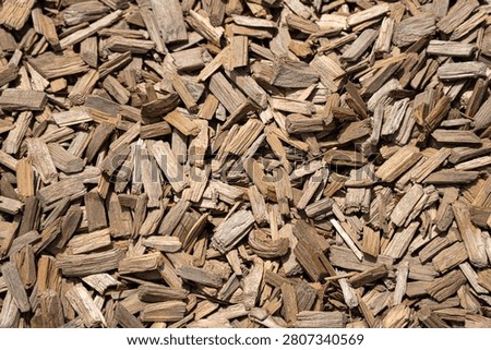 Full frame top view texture of natural brown wood chips mulch used for garden landscaping and playground safety surfacing.