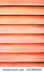 Full frame view horizontal window slats and bright orange tint 