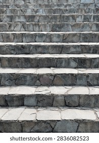 Full frame view of rustic stone stairs. Sharp focus reveals rough-cut slate textures and subtle mineral tones under soft natural light. Ideal for background texture, architecture mockups, or design projects.