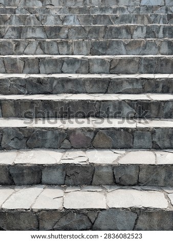 Full frame view of rustic stone stairs. Sharp focus reveals rough-cut slate textures and subtle mineral tones under soft natural light. Ideal for background texture, architecture mockups, or design projects.