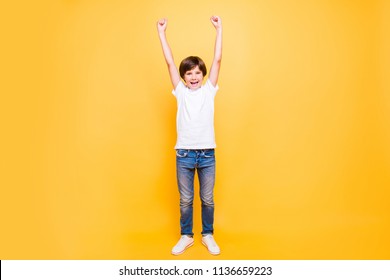 Full height portrait of attractive young cheerful school boy, smiling standing raising hands up over yellow background, isolated. Copy space - Powered by Shutterstock