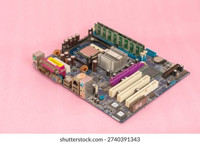 Full high-angle view of a vintage computer motherboard featuring a CPU, RAM modules, heatsink, and various connection ports on a minimalist pink background