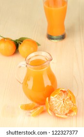 Full jug of tangerine juice, on wooden background - Shutterstock ID 122327377