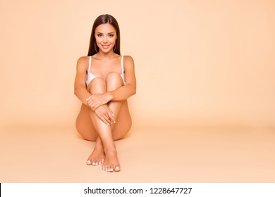 Full Legs Body Size Portrait Of Brunette Hair Lady She Hug Herself Self Sitting On The Floor Isolated On Pastel Beige Background With Her Perfect Ideal Slim Fit Figure Make Beaming Smile