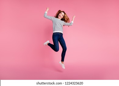 Full legs length body size portrait of lifestyle lady with her modern trendy brown curly wave hair she isolated on pink background in shoes casual outfit striped clothes denim jeans raised fists up - Shutterstock ID 1224323620