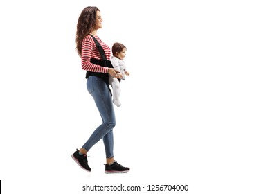 Full Lenght Shot Of A Young Mother With A Baby In A Carrier Walking Isolated On White Background