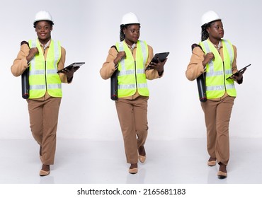 Full length 20s young African American Woman Architecture Engineer, walking forward left right, wear formal pants and shoes. Contractor female carry internet tablet over white background isolated