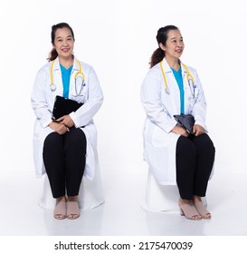 Full Length 40s 50s Asian Senior Woman Medical Healthcare Doctor, Sitting Diagnostic Patient, Wear White Coat Lab Pant. Smile Hospital Female Sit Checking Examine Status Over White Background Isolated