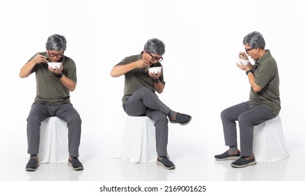 Full Length 50s 60s Asian Chinese Shop Owner Man, Eating Food Chopstick Bowl, Wear Formal Casual Dress Sit On Chair. Old Middle Age Male Sitting And Turn Many Angle Over White Background Isolated