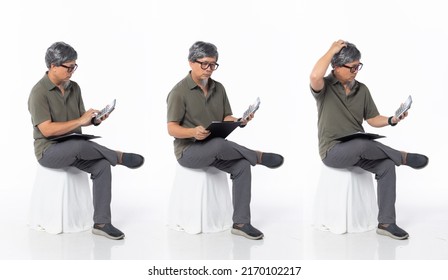 Full Length 50s 60s Asian Chinese Shop Owner Man, Doing Account Tax Finance, Wear Formal Casual Dress Sit On Chair. Old Middle Age Male Sitting And Check Calculator Over White Background Isolated