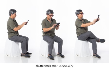 Full Length 50s 60s Asian Chinese Shop Owner Man, Working Internet Phone, Wear Formal Casual Dress Sit On Chair. Old Middle Age Male Sitting And Turn Many Angle Over White Background Isolated