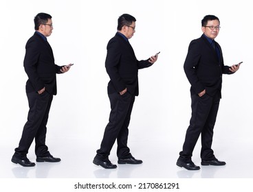 Full Length 60s 50s Asian Senior Man Business Executive Manager, Walking Forward Left Right, Wear Black Formal Suit. Confident Office Male Carry Internet Phone Over White Background Isolated