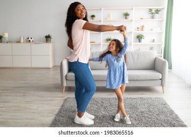 Full Length Of African American Mother Dancing To Music With Her Cute Little Daughter At Home. Black Mom And Her Kid Enjoying Favorite Song Together, Fooling Around, Having Fun