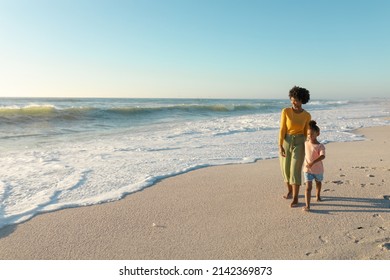 Full length of african american mother and daughter walking on shore at beach with copy space. unaltered, family, lifestyle, togetherness, enjoyment and holiday concept. - Shutterstock ID 2142369873