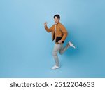 Full length Asian man holding tablet running with happy smile isolated on blue background. Happy man joyful run in copy space.