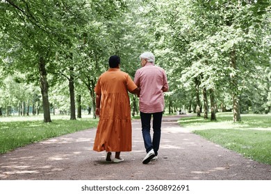 Full length back view of happy senior couple walking on park lane together and holding hands - Powered by Shutterstock