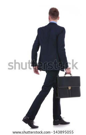full length back view picture of a young business man with a suitcase in his hand walking away. on white background