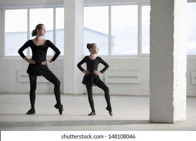 Full length of ballerina teaching young girl in empty warehouse - Powered by Shutterstock