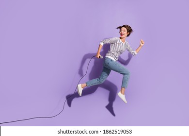 Full Length Body Photo Of Cheerful Ecstatic Lady Holding Mic Hurrying On Stage Jumping Up Isolated Over Violet Color Bright Background