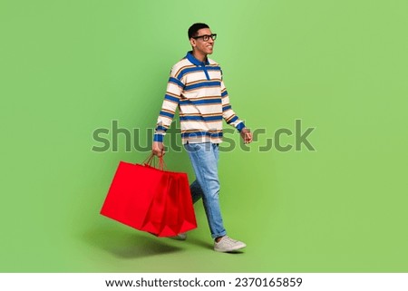 Full length body photo of man brand store advert billboard walking bring bags packages look mockup isolated on green color background