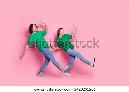 Full length body photo of two best friends teenagers synchronized moves dancing together boogie woogie isolated on pink color background