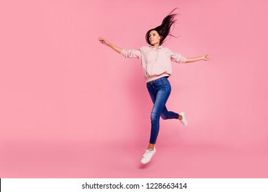 Full length body size of nice cute dreamy lovely attractive adorable sweet charming positive girl strolling in air having fun isolated over pastel pink background