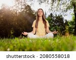 Full length body size photo woman sitting on grass practising yoga excercises in summer park