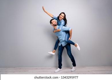 Full length body size photo funky cheer she her he him his lady guy piggyback ride walk meet adventures hand arm up run runner wear casual jeans denim shirts outfit clothes isolated grey background - Powered by Shutterstock