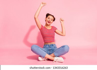 Full length body size photo beautiful she her lady buns pomade lips hands arms up air eyes closed cheerleader wear casual jeans denim striped red white t-shirt sit floor isolated pink background - Powered by Shutterstock