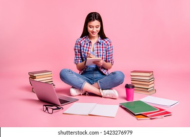 Full length body size photo beautiful she her sit floor notebook hands organizer make notes college website surround learn stuff wear casual checkered plaid shirt jeans denim isolated pink background