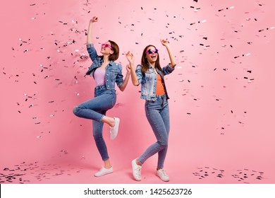 Full length body size photo beautiful she her sisters ladies festive hands raised listen playlist clubbing celebrate confetti fly fall wear jeans denim jackets blazers isolated bright pink background