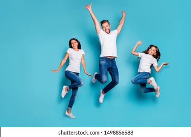 Full length body size photo of jumping enjoying nice glad family cute wearing white t-shirts jeans denim while isolated with blue background - Powered by Shutterstock