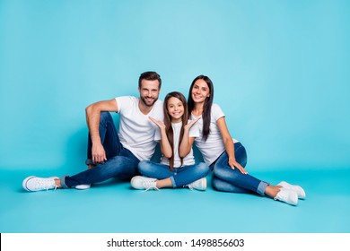 Full Length Body Size Photo Of Family Sitting On Floor Giving You Toothy Smiles While Isolated With Blue Background