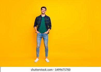 Full length body size photo of handsome man holding hands in jeans pockets wearing plaid shirt denim footwear stand isolated over bright color background standing posing confidently - Powered by Shutterstock