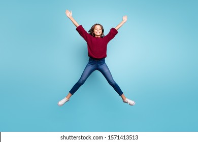 Full length body size photo of cheerful curly positive preteen shaping star with her legs arms jumping free isolated vivid blue color background - Shutterstock ID 1571413513