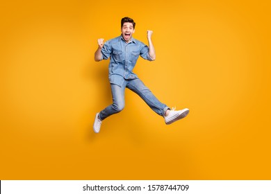 Full length body size photo of cheerful positive overjoyed man excited about having won competitions jumping up isolated vivid color background