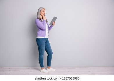 Full Length Body Size Photo Of Senior Woman Smiling Working With Laptop Reading Touching Her Face Wearing Eyeglasses Casual Outfit Isolated On Grey Color Background