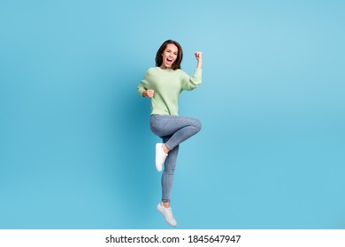 Full length body size photo of funky jumping up girl wearing casual clothes shouting loudly like a winner smiling isolated on bright blue color background