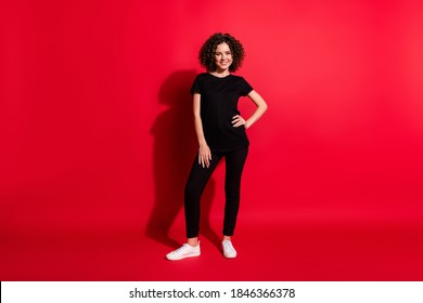 Full length body size photo of young beautiful woman curly brown hair wear casual outfit isolated over red color background